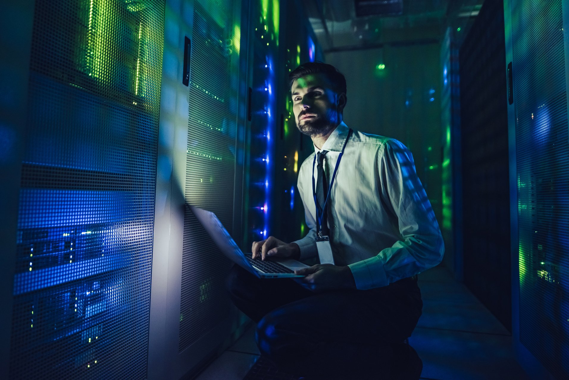 Handsome man is working in data centre with laptop.